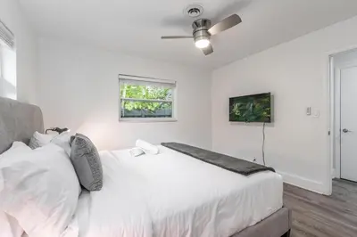 a white bedroom with a bed and a ceiling fan at New Apt 2 Bed 2 Bath with Amazing PATIO in Fort Lauderdale