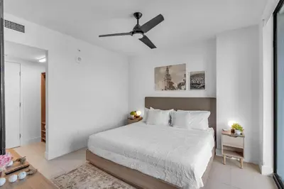 a white bedroom with a bed and a ceiling fan at Bright and Breezy 1 Bed Unit With Water and City Views in Miami
