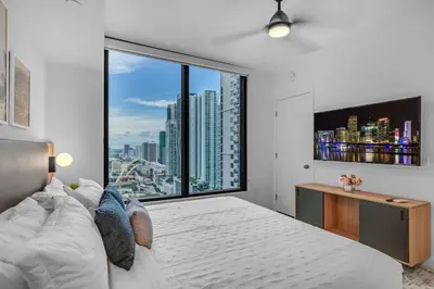 a bedroom with a large bed and a large window at Experience Miami Vibes in the Heart of Downtown in Miami