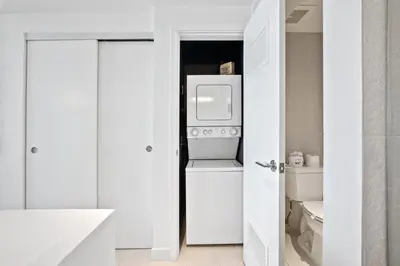 a white bathroom with a refrigerator and a toilet at 23rd Floor W 2BR with Den, Ocean Views, Sleeps 8 in Fort Lauderdale