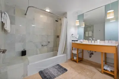 a bathroom with a tub and a sink and a shower at Luxury Top-Level Oasis - Oceanfront Views & Resort Perks in Sunny Isles Beach