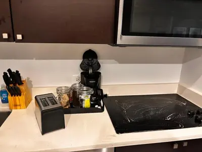 a kitchen counter with a stove and a microwave at Provident Doral at The Blue in Miami