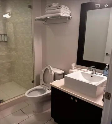 a bathroom with a toilet and a sink and a shower at Provident Doral at The Blue in Miami
