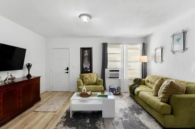 a living room with a green couch and a table at Brickell Stay: Near Beach Downtown Pet-Friendly in Miami