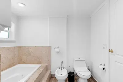 a bathroom with a tub and a toilet and a sink at Stunning Tropical Pool House Miami Coconut Grove in Miami