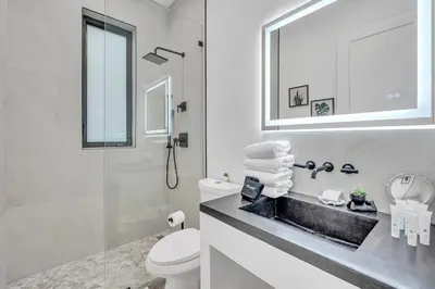 a bathroom with a sink and a toilet and a mirror at Wonderful New Tropical Pool House North Miami in Gold Coast Heliport