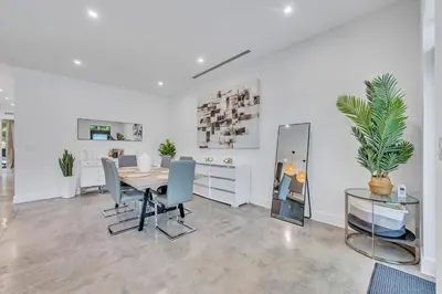 a dining room with a table and blue chairs at Wonderful New Tropical Pool House North Miami in Gold Coast Heliport