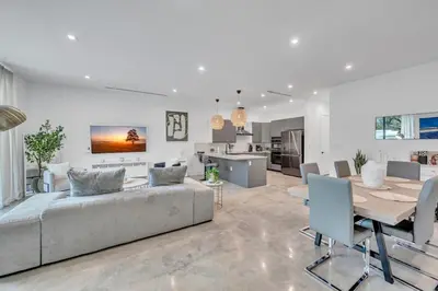 a living room with a couch and a table and a kitchen at Wonderful New Tropical Pool House North Miami in Gold Coast Heliport