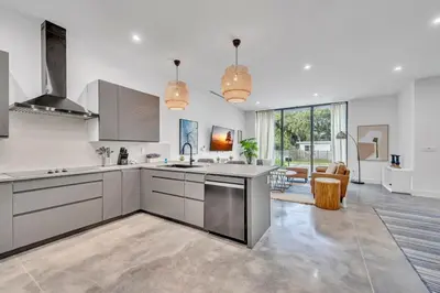 a kitchen with white walls and stainless steel appliances at Stunning Tropical Pool House North Miami in Gold Coast Heliport