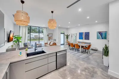 an open kitchen and living room with a dining room at Stunning Tropical Pool House North Miami in Gold Coast Heliport