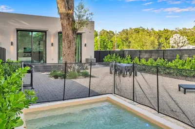 a swimming pool in a backyard with a fence at Stunning Tropical Pool House North Miami in Gold Coast Heliport