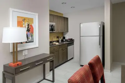 a kitchen with a refrigerator and a table with a lamp at Homewood Suites by Hilton Miami Downtown/Brickell in Miami