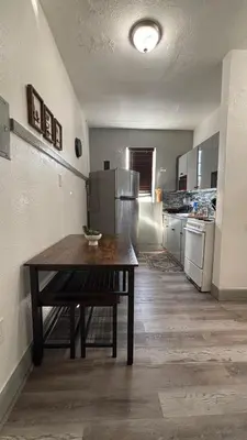 a kitchen with a table and a refrigerator at Noemi's Studio Suite Steps To Marlins Stadium At Little Havana in Miami
