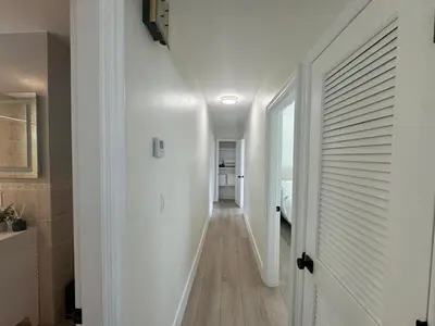 a hallway with white walls and a white door at Chic-ness Oasis NOW HEATED POOL ! in Cutler Bay