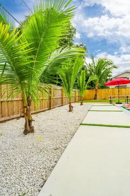 a sidewalk with palm trees and a red umbrella at Modern & Cozy Private Pool Home in Parkway Regional Medical Center Heliport