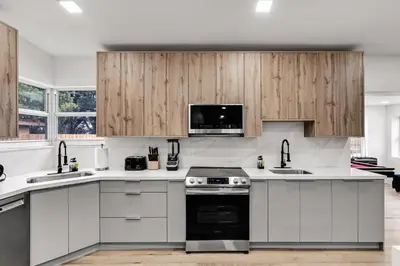 a kitchen with white counter tops and wooden cabinets at Modern & Cozy Private Pool Home in Parkway Regional Medical Center Heliport