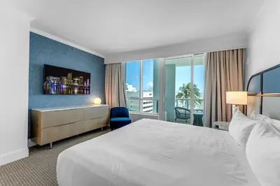 a hotel room with a large bed and a window at FontaineBleau Suite at Miami Beach in Miami Beach