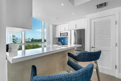 a kitchen with two blue chairs and a counter at FontaineBleau Suite at Miami Beach in Miami Beach