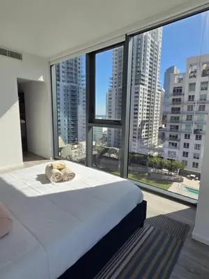 a bedroom with a bed and a large window at Miami-Brickell Luxury 2BR-2BATH with skyline VIEWS - walking distance to KASEYA-HEAT ARENA & BAYSIDE - Port of MIAMI cruise ships in Miami