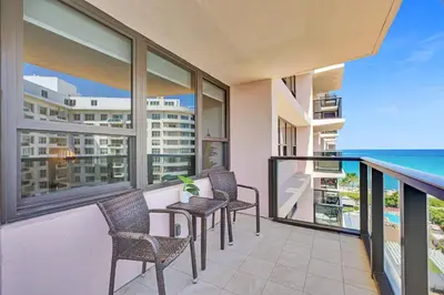 a balcony with chairs and a view of the ocean at Modern Ocean Escape Stylish 2BR Condo with Resort Amenities Pools Sauna and Gym 1417 in Miami Beach