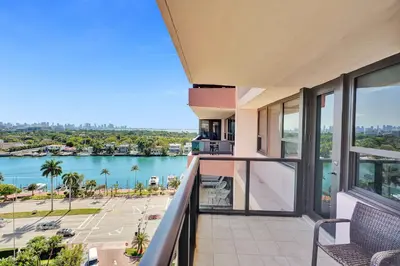 a balcony with a view of a body of water at Modern Ocean Escape Stylish 2BR Condo with Resort Amenities Pools Sauna and Gym 1417 in Miami Beach