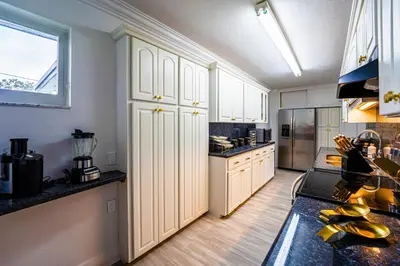 a large kitchen with white cabinets and a window at Top Villa Near Beach with Game Room, Hot Tub and Pool in Pembroke Pines