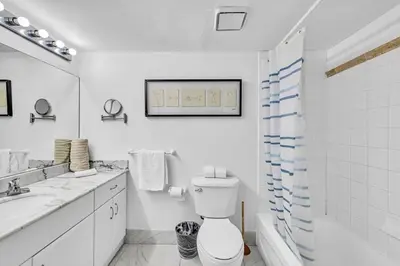 a white bathroom with a toilet and a sink at Central Unit in Heart of Brickell in Miami