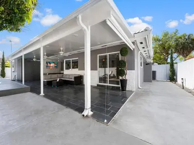 a large white house with a large patio at The Chill Sunny Casa Near Beaches in Miami Lakes