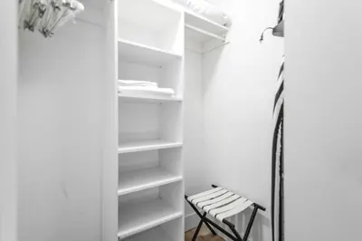 a closet with white shelves and a chair at Oceanfront Retreat Scenic Views & Coastal Comfort in Hollywood