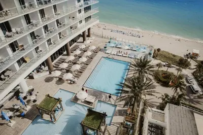 an aerial view of a hotel with a pool and a beach at Oceanfront Retreat Scenic Views & Coastal Comfort in Hollywood