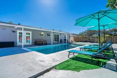 a swimming pool with two chairs and an umbrella at Relax & Fun Hollywood Private Pool | Arcade Game in Hollywood