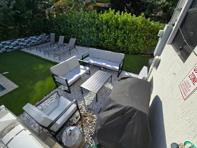 an aerial view of a patio with chairs and a table at Lux Retreat with Pool Near Beach in Fort Lauderdale