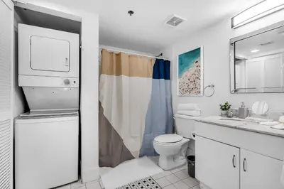a white bathroom with a toilet and a sink at Relaxing 1-Bed Condo With City Views in Brickell Key in Miami
