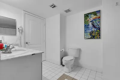 a bathroom with a toilet and a painting on the wall at Elegant 1 BR Retreat in Brickell With Free Parking in Miami
