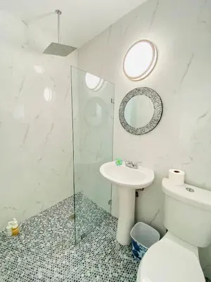 a bathroom with a toilet and a sink and a mirror at Walk to Calle 8 - Authentic Cuban Experience in Miami