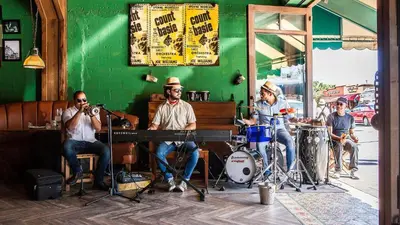 a group of people playing music on the street at Walk to Calle 8 - Authentic Cuban Experience in Miami