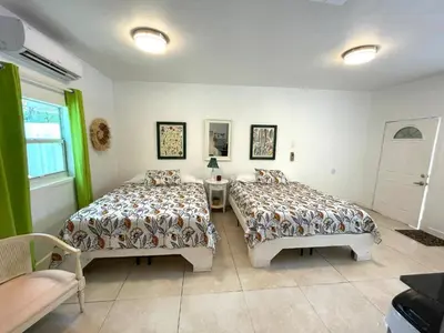 a bedroom with two beds and a table and a window at Unique Studio in Little Havana Reserved Parking in Miami