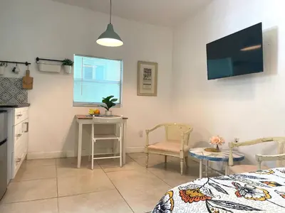 a room with a bed and a table and a kitchen at Unique Studio in Little Havana Reserved Parking in Miami