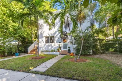 a white house with palm trees in front of it at Tropical Paradise in Miracle Mile with Parking in Miami