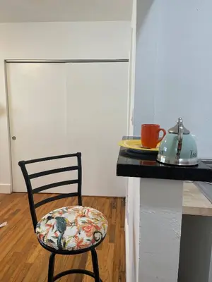 a chair sitting next to a kitchen counter with a table at Tropical Paradise in Miracle Mile with Parking in Miami