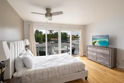 a bedroom with a bed and a television and a balcony at Waterside retreat in Fort Lauderdale