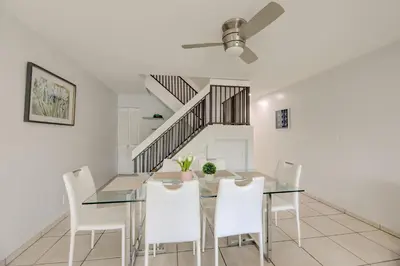 a dining room with a glass table and white chairs at Waterside retreat in Fort Lauderdale