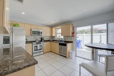 a kitchen with wooden cabinets and a counter top at Intracostal Beauty in Fort Lauderdale