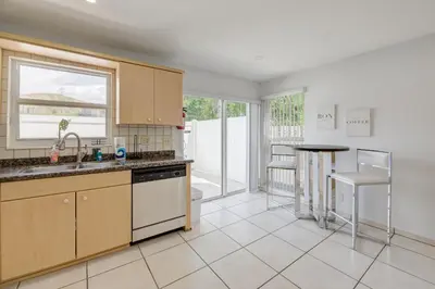 a kitchen with wooden cabinets and a sink and a table at Intracostal Beauty in Fort Lauderdale