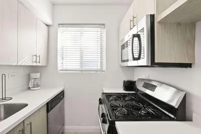 a kitchen with a stove top oven in a kitchen at Modern Miami Beach Apt King & Sofa Bed Comfort in Miami Beach
