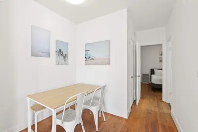 a white dining room with a wooden table and chairs at Modern Miami Beach Apt King & Sofa Bed Comfort in Miami Beach