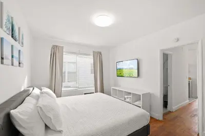 a white bedroom with a bed and a window at Modern Miami Beach Apt King & Sofa Bed Comfort in Miami Beach