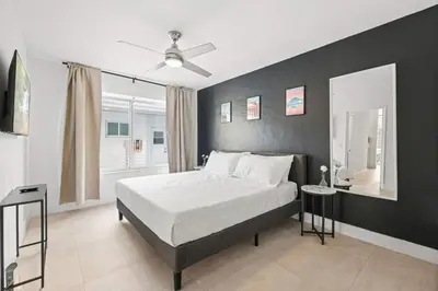 a bedroom with a bed and a black wall at Miami Magic 1BR 4 Guests in Miami Beach