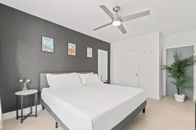 a bedroom with a white bed and a ceiling fan at Miami Magic 1BR 4 Guests in Miami Beach