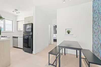 a kitchen with a black refrigerator and a table at Miami Magic 1BR 4 Guests in Miami Beach